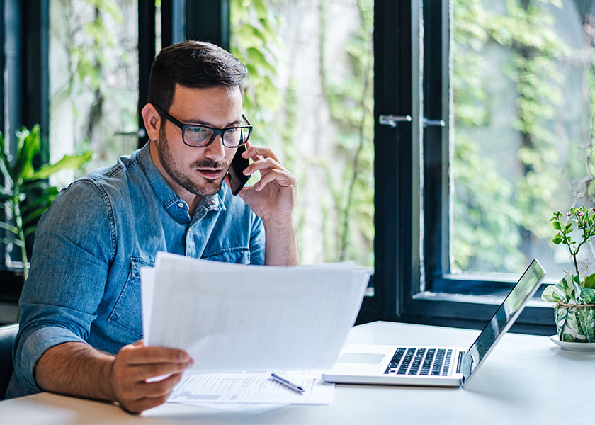 Small business owner looking over life insurance paperwork.